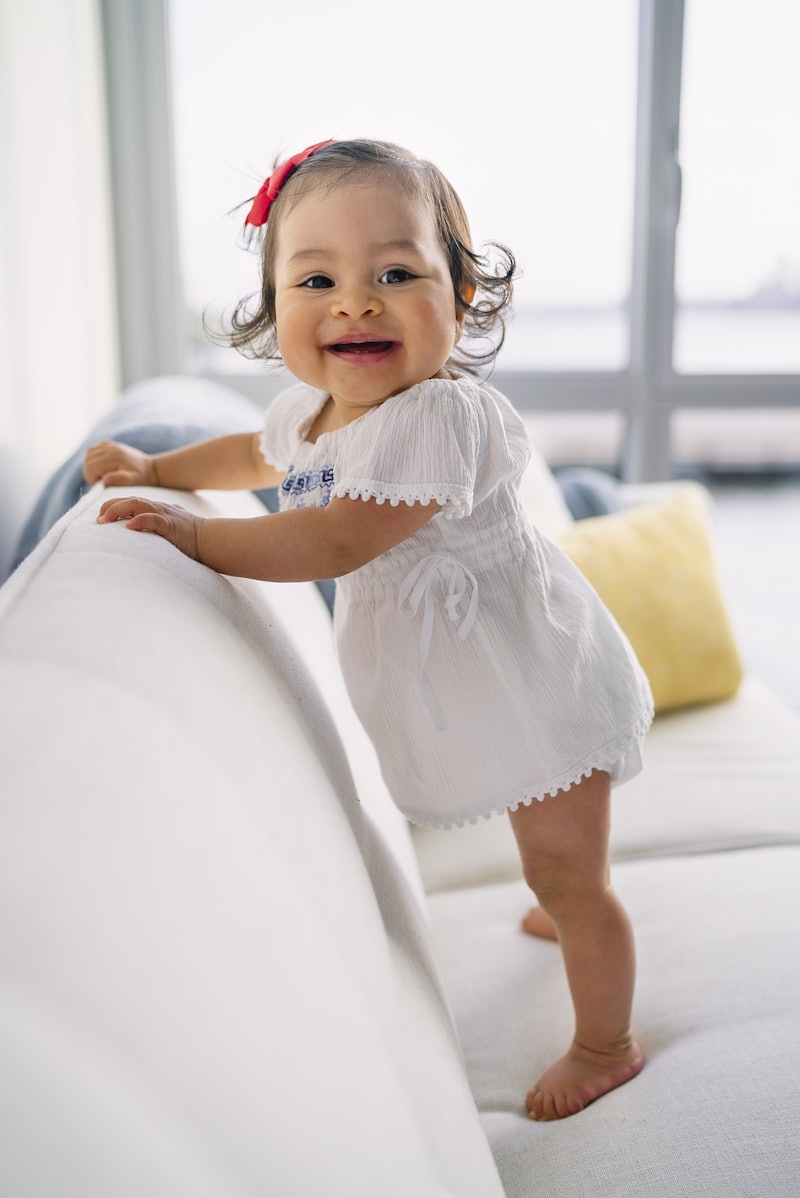 Niña pequeña de pie, sonriendo