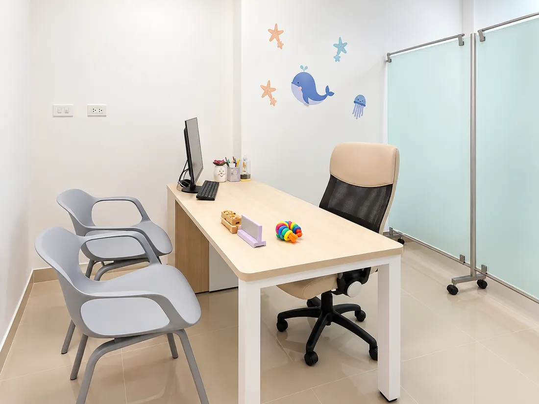 Escritorio de consulta con la silla de la doctora y las de la familia