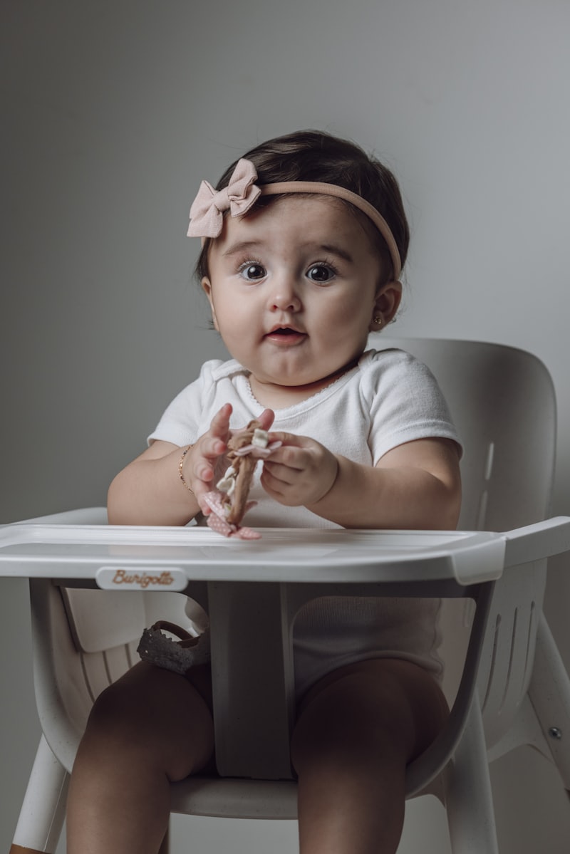 Bebé comiendo con cuchara en su silla